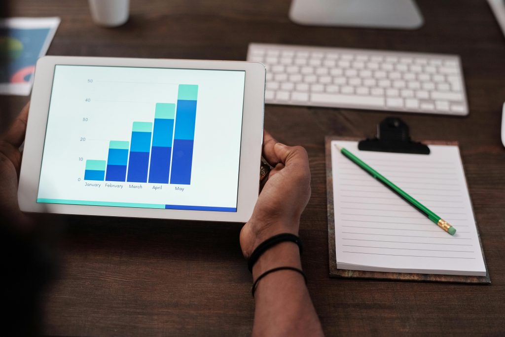 SEO meaning in business showing growth charts on a wooden desk setup.